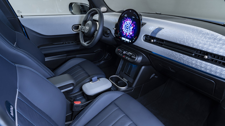 looking in through the passenger side window of a Mini Cooper showing a blue interior with a light colored dash