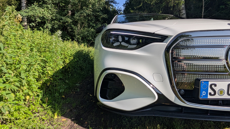 a close up of a white electric Mercedes-Benz C-Class sedan's headlight