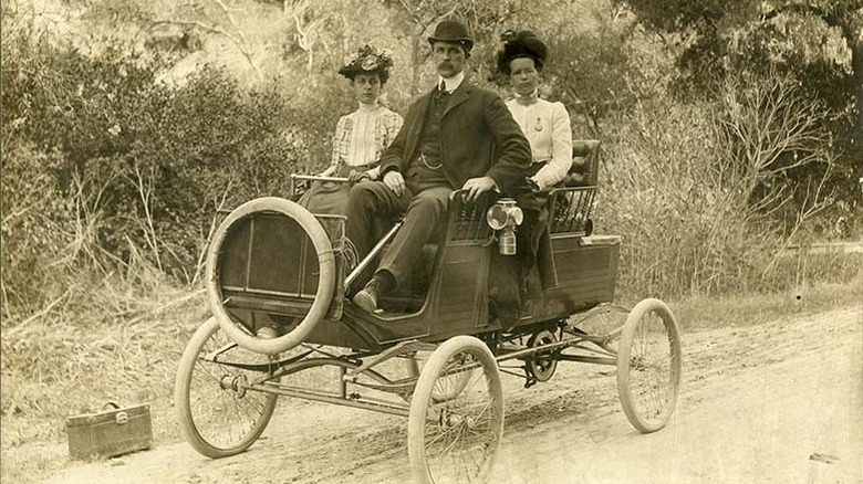 A Model 3 Surrey "Locomobile" four-passenger steam car manufactured in Connecticut, seen in 1901. It's carrying Miss Edna Dahl and Mr. and Mrs. Elgin Stoddard.