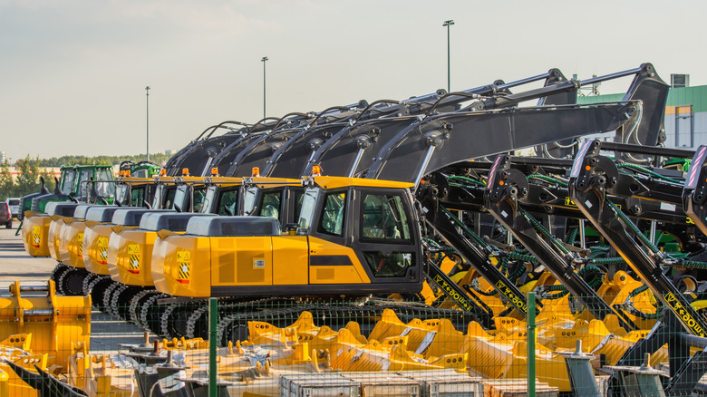 New yellow and black excavators parked on a lot.