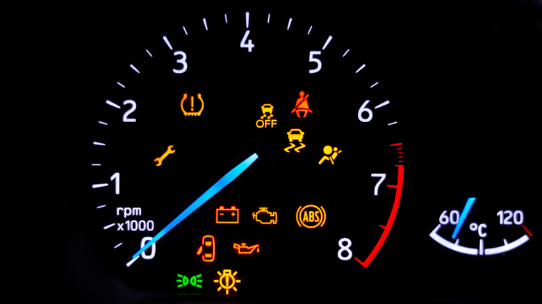 A car's dashboard lights up with multiple alert icons, signaling various vehicle functions and warnings in a clear, colorful display.